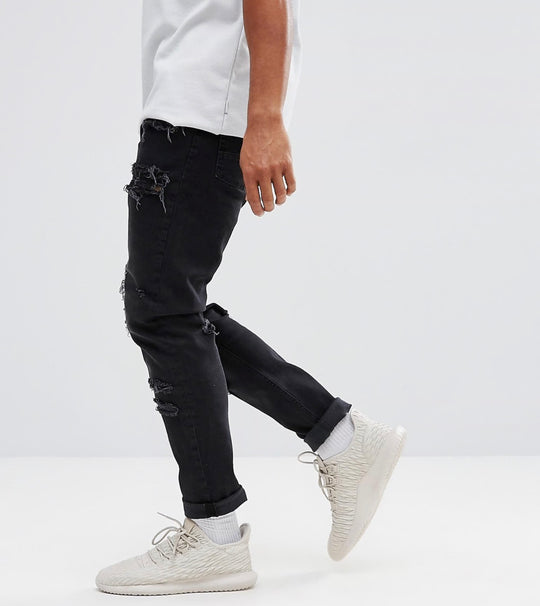 ASOS DESIGN tapered jeans in washed black with heavy rips